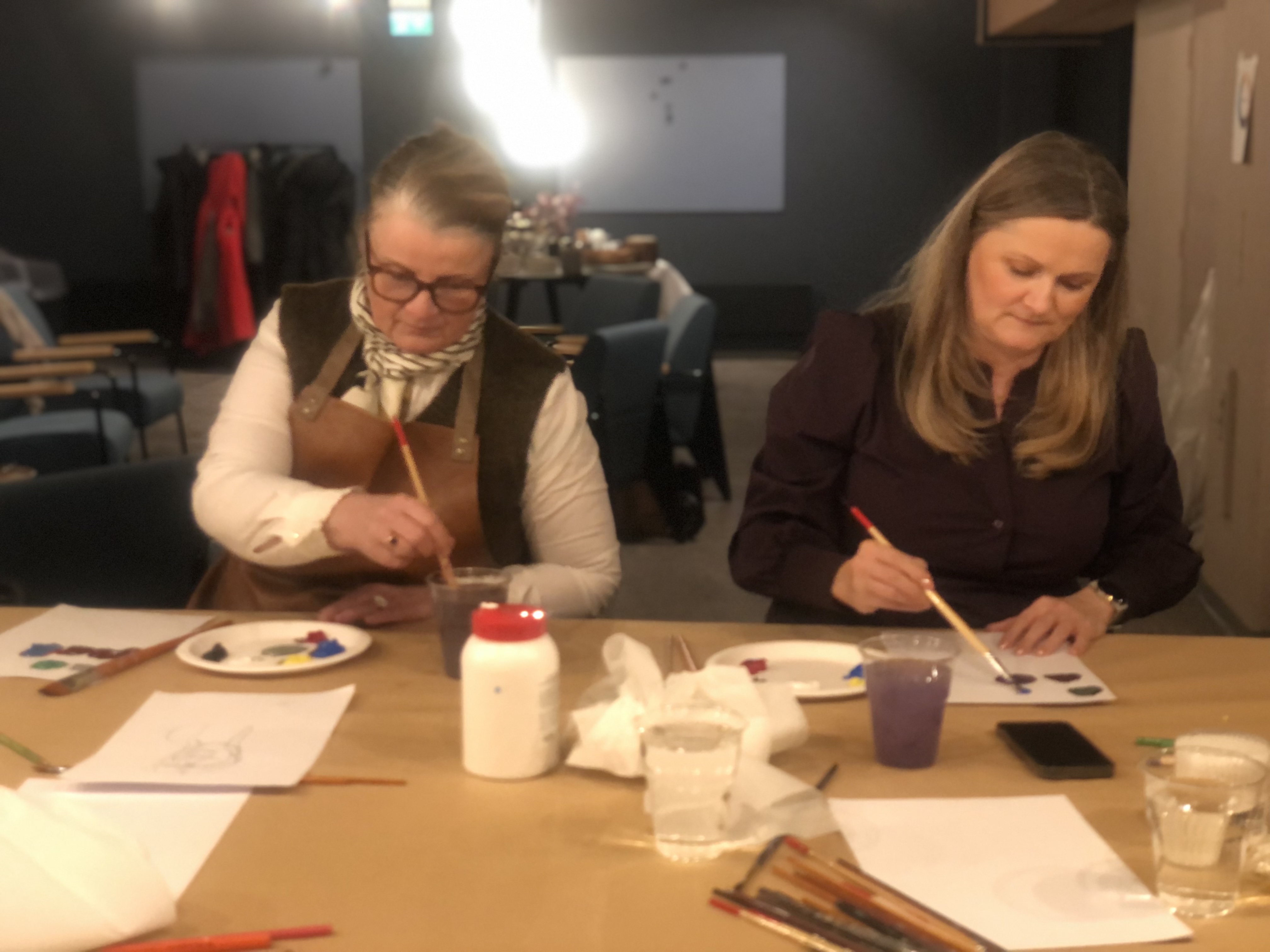 Else Gullestad and a participant focused on their paintings at a Blanke ark til mesterverk workshop